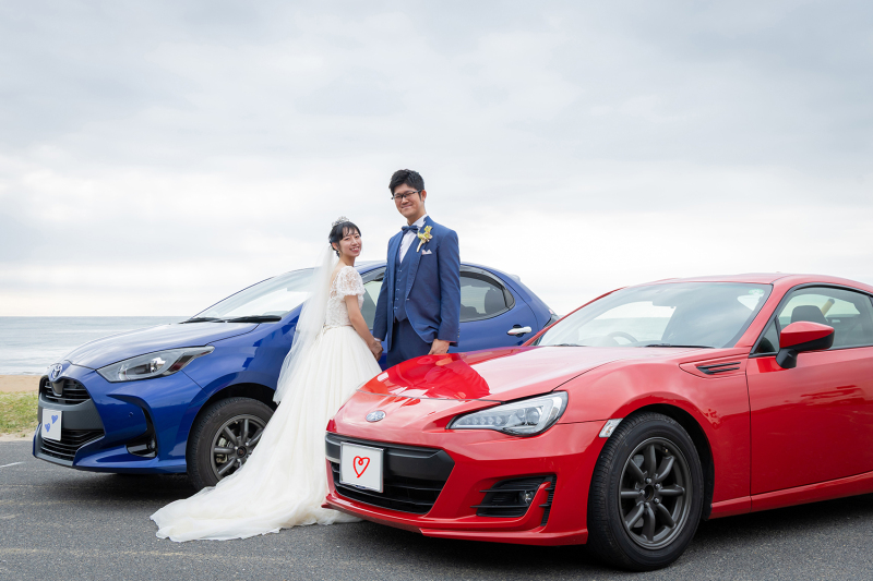 青と赤の愛車に挟まれて微笑むウェディングショット