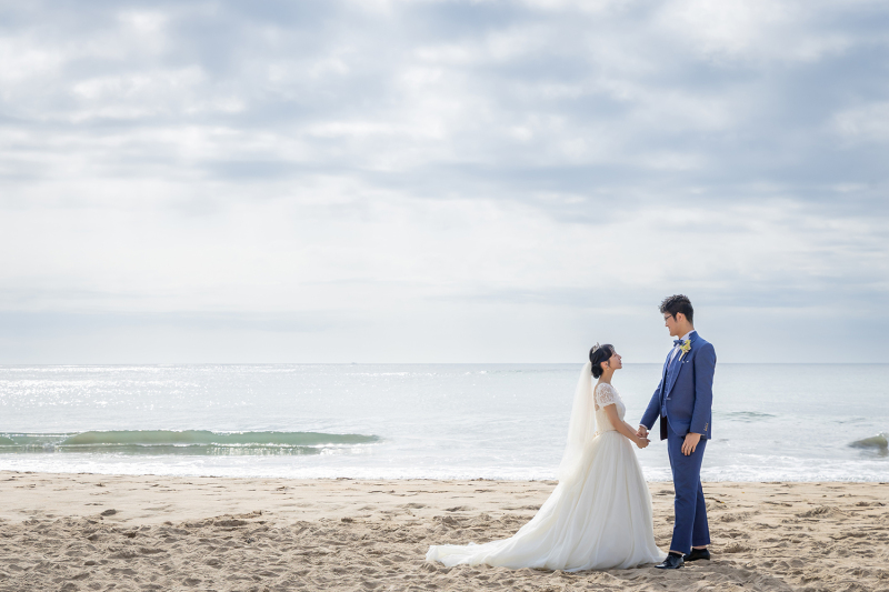 広大な海と砂浜で静かに手を取り合うシルエット