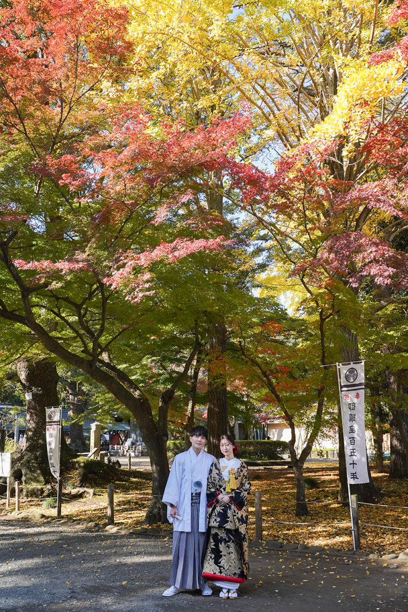 紅葉と緑が織りなす境内で寄り添う二人
