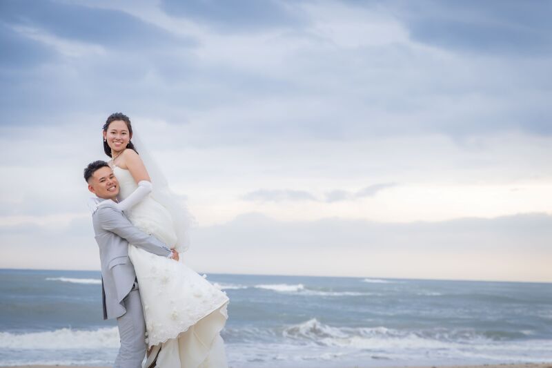 波を背景に笑顔のふたり