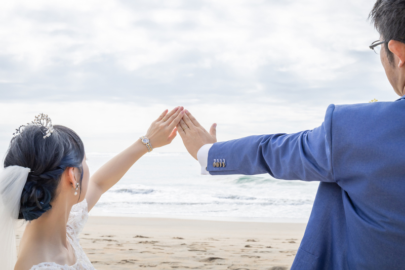 キラキラ輝く海を背景に重ね合わせる結婚指輪