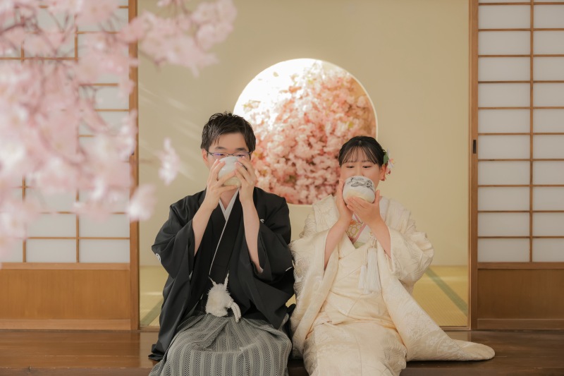 縁側で仲良く腰掛けながら抹茶を飲むおふたり。
