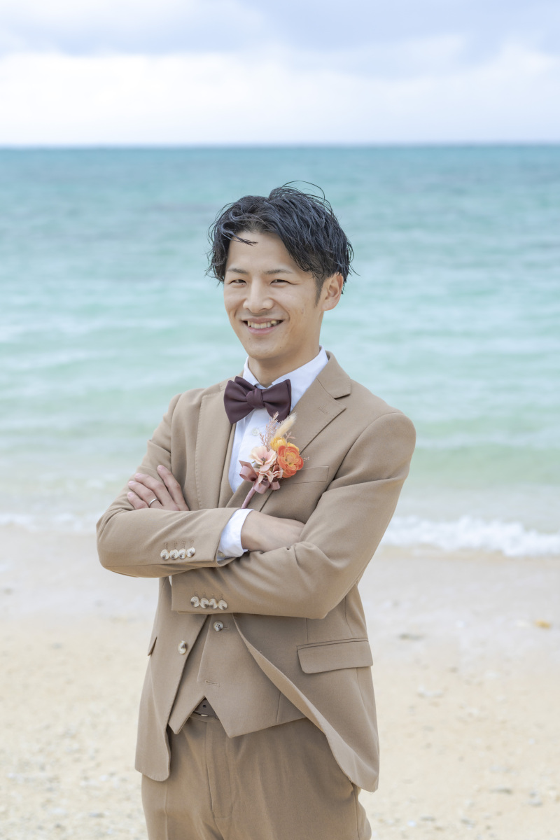 青い海をバックにした爽やかなスーツ姿