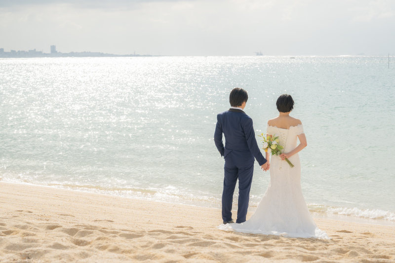 きらめく海を眺めて手をつなぐ後ろ姿