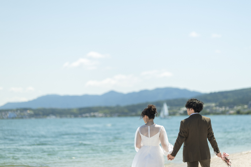 歩いていく二人の間にヨットを入れて。