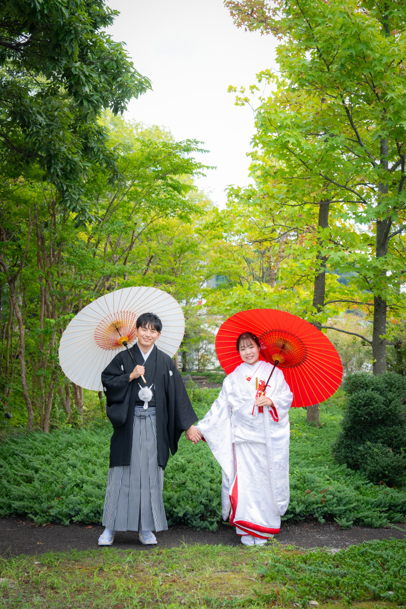 豊かな緑の中でカラフルな和傘が彩る二人