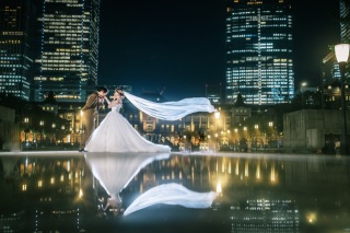 東京駅舎を背景に、美しいベールの曲線を描く写真。妻との息の合った連携が生み出した一枚。夫婦ならではの絶妙なコンビネーションで完成した作品。