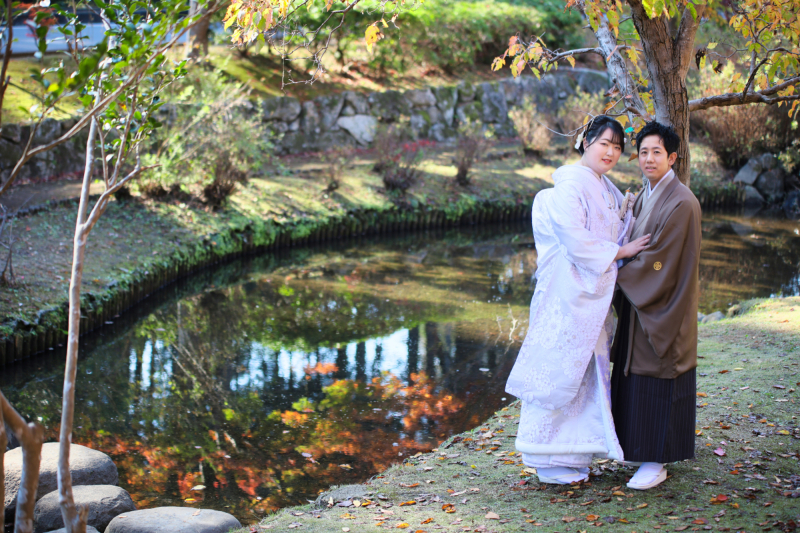 おふたりと水面に映る紅葉と