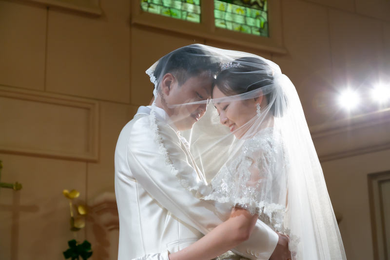 ステンドグラスがベールの中の二人を優しく包む