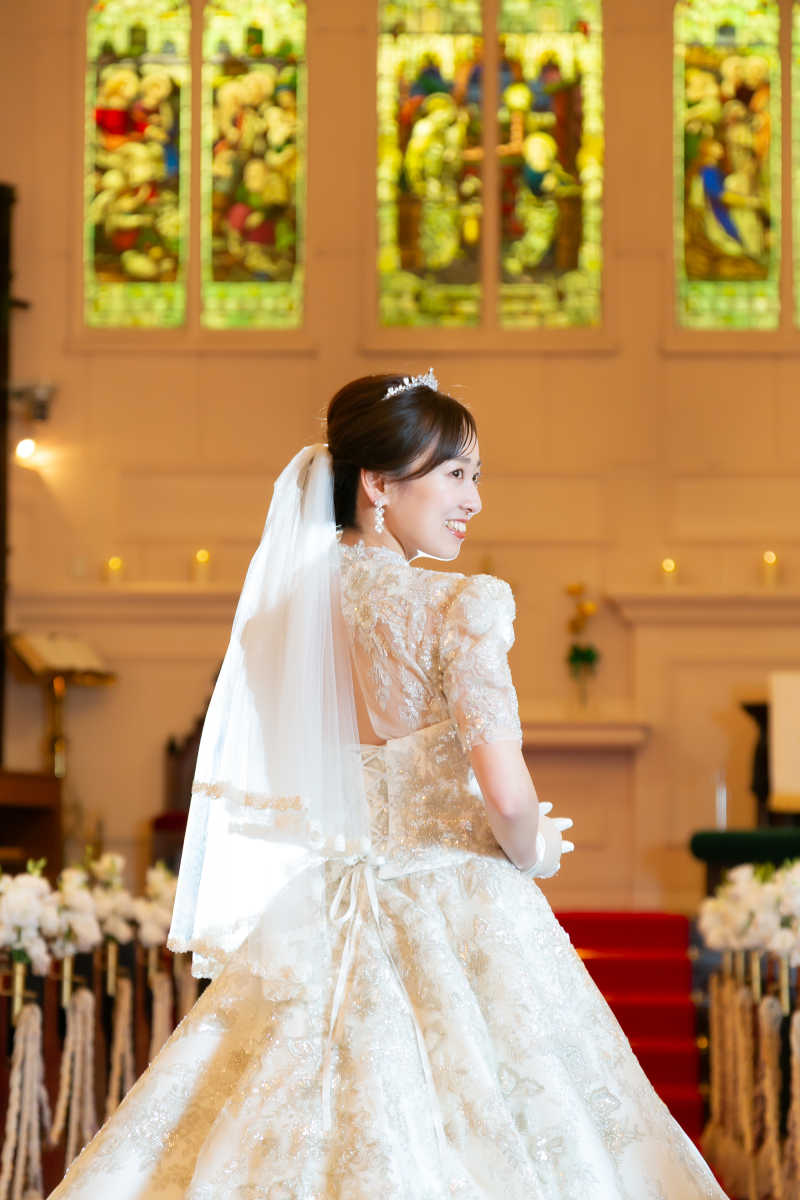 ステンドグラスを背に、ドレスのご新婦様