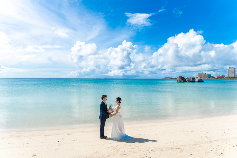  美しいビーチで向かい合い、手を繋ぐお二人