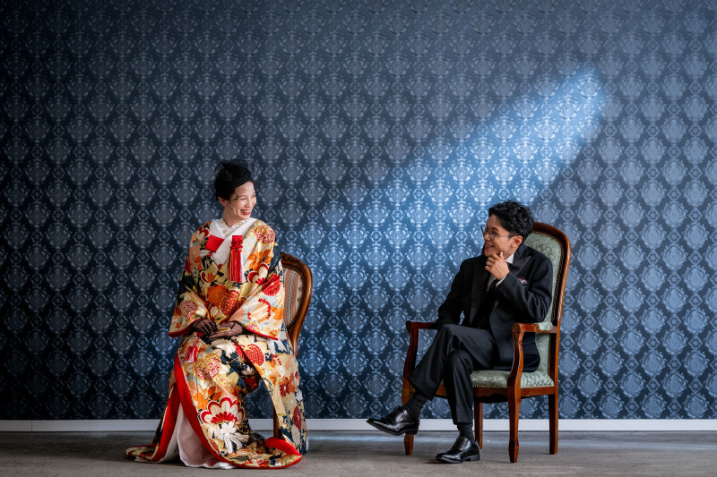 スタジオの青背景に和装とタキシードで