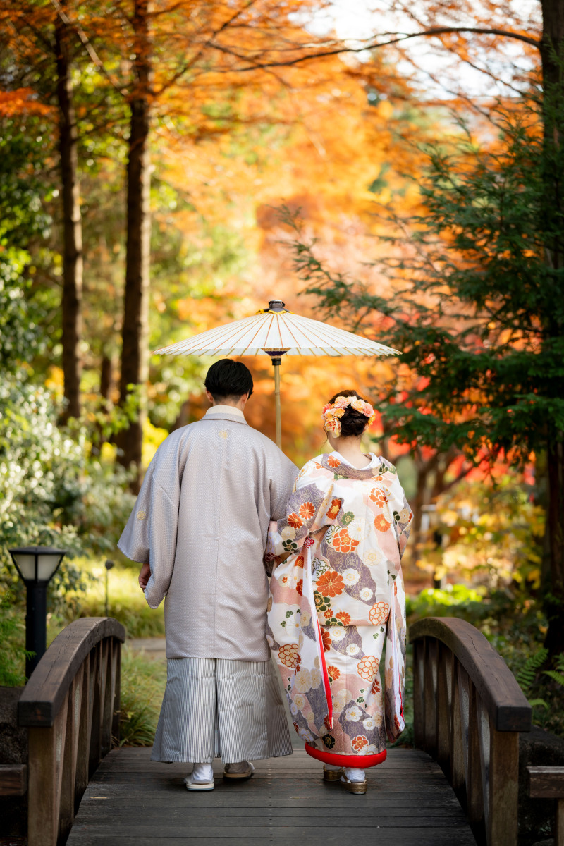 紅葉の中、自然に歩くお二人の後ろ姿