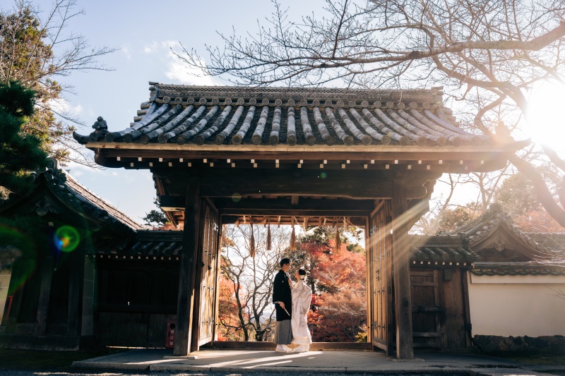 光と紅葉が彩る毘沙門堂門前、白無垢の新郎新婦