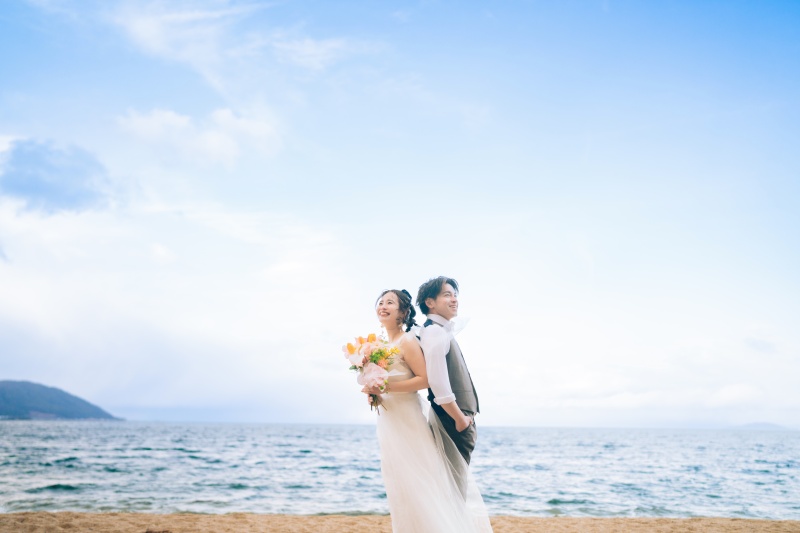 青空の下で笑顔の洋装ショット