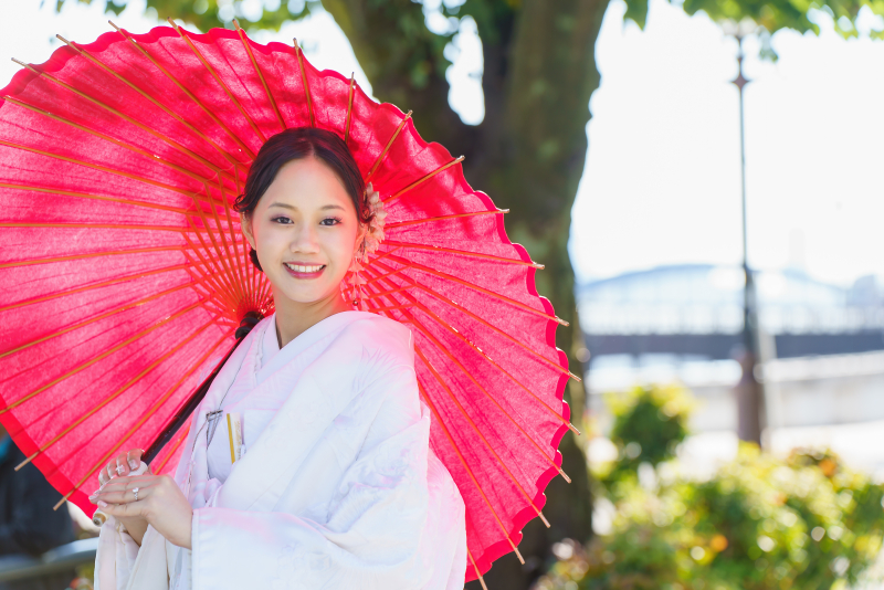 赤い和傘に白無垢が映える新婦様の特別ショット。