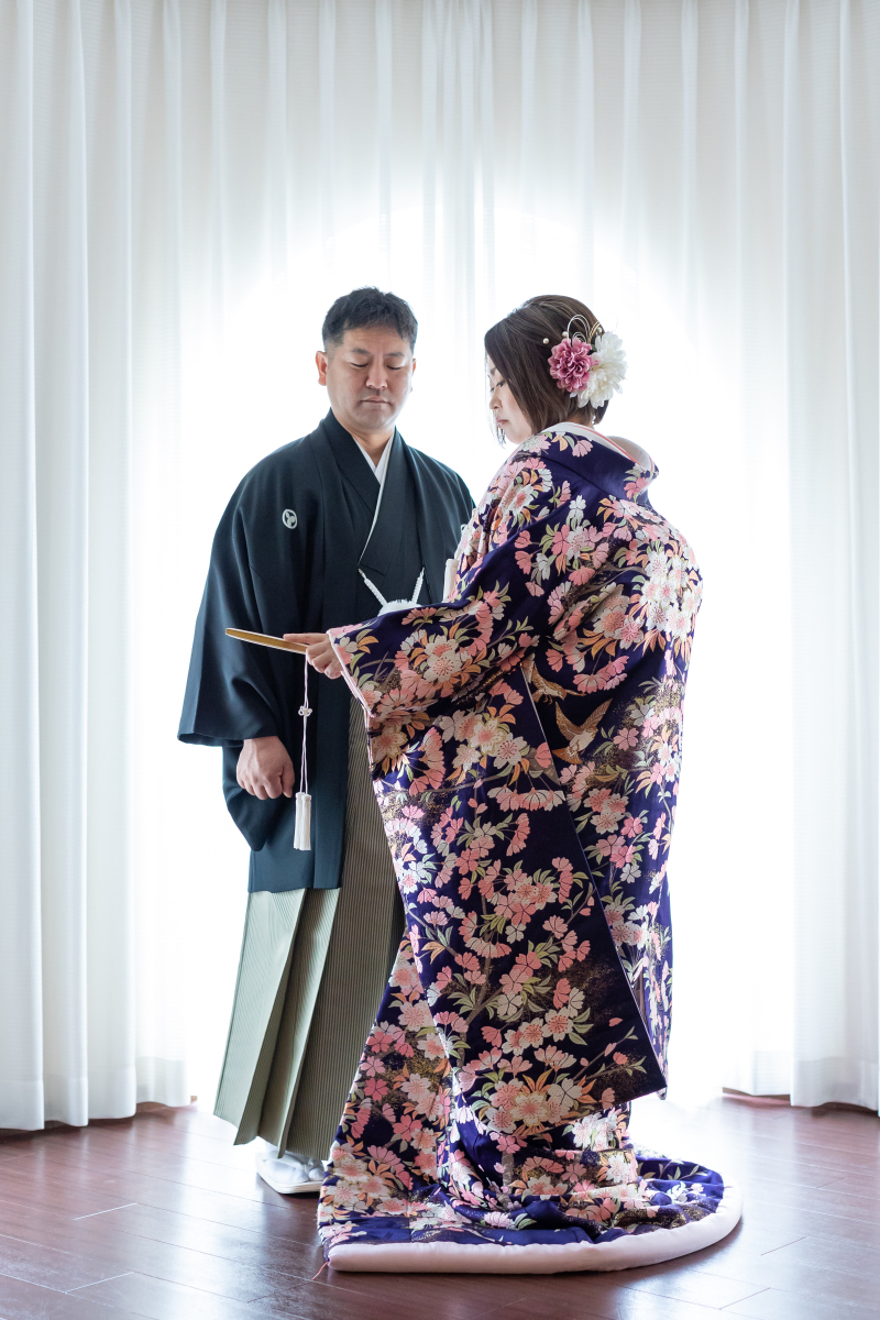 光あふれるカーテンの前で佇む情緒的な和装姿