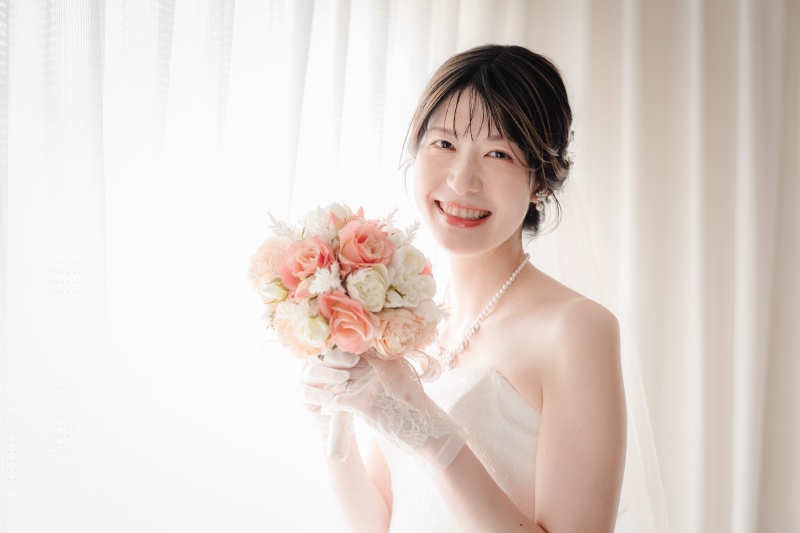 光を纏う花嫁。ブーケを胸に魅せる優しげな表情