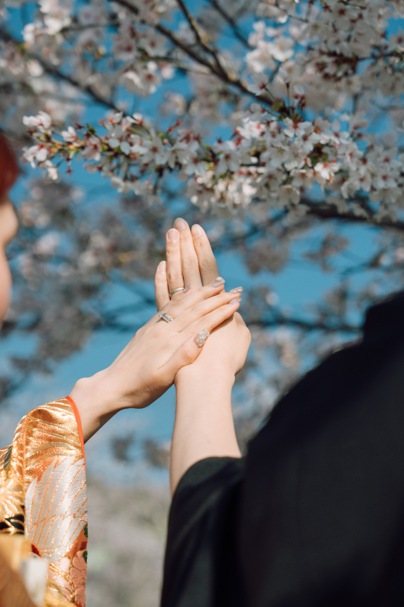 青空に映える手元。薬指に輝く誓いのしるし