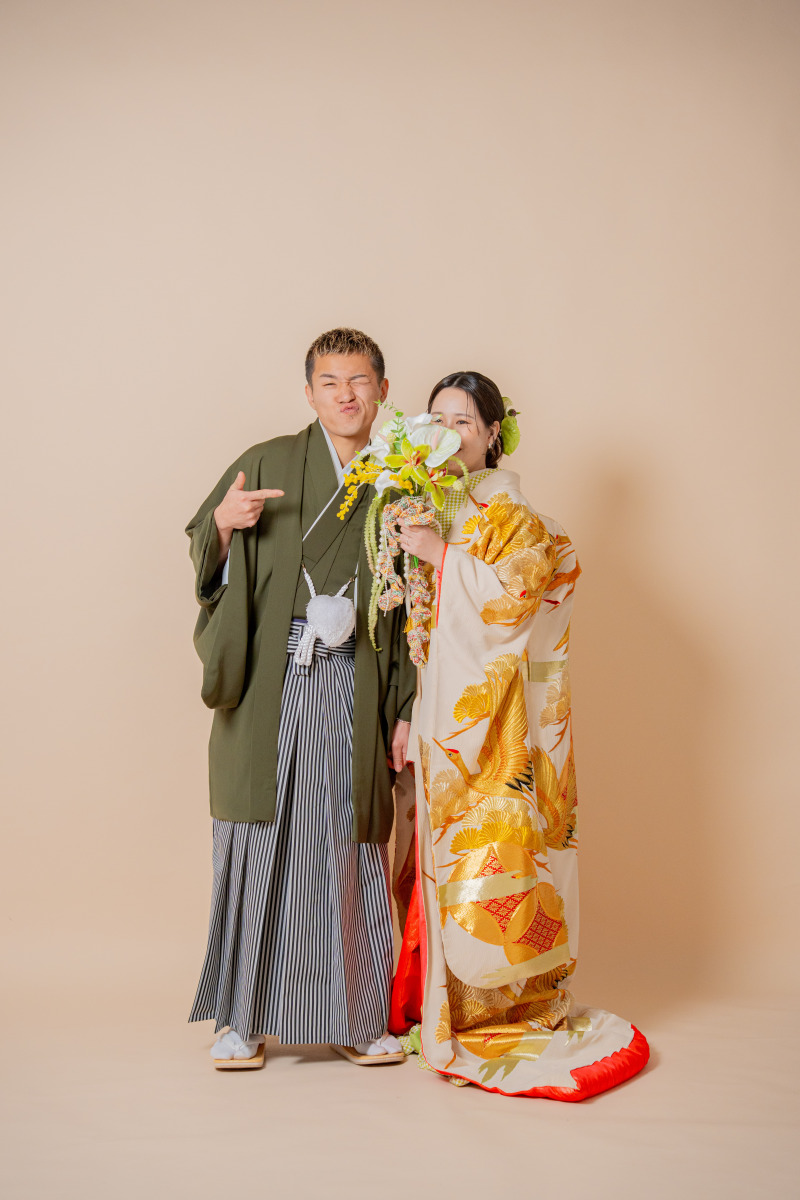 鮮やかなブーケで顔を隠したお茶目な一枚
