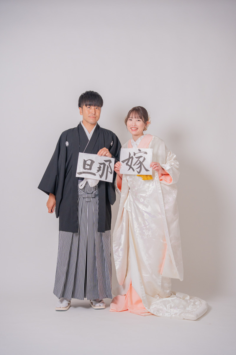 「旦那」「嫁」習字紙を持ったポーズ