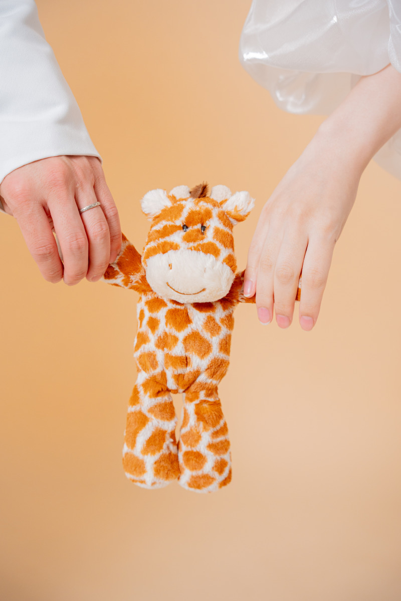 キリンのぬいぐるみと手を繋いで