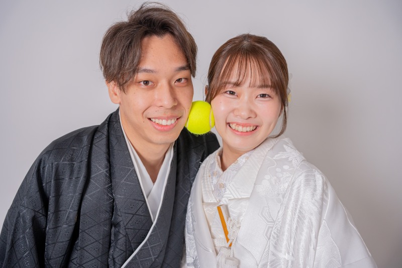 テニスボールを挟んだお茶目な笑顔