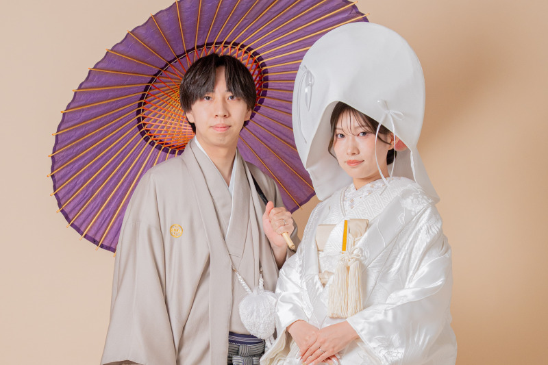 紫の和傘と綿帽子で凛とした表情