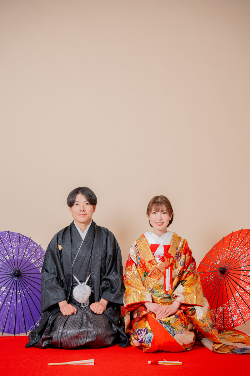 緋毛氈に座り、三つ指をついて