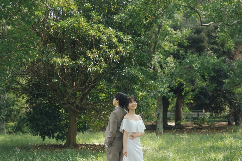 緑の中でウエディングドレス姿が輝く一枚