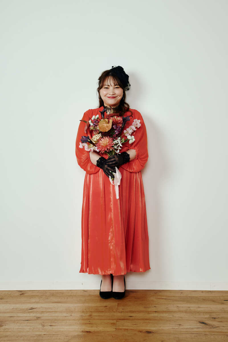 白壁のスタジオに映える赤のワンピース