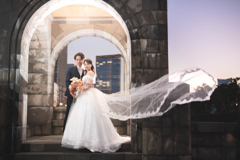 日の入り時刻、柔らかな光に包まれる中で撮影した一枚。風になびく新婦のドレスが美しく動きを添え、自然な表情と空気感を引き立てます。特別な瞬間をより印象的に残せるよう、光や角度にもこだわりました。