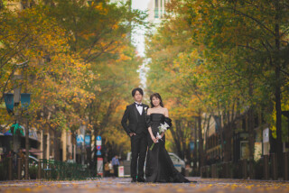 紅葉に彩られた並木道で、おふたりの自然な姿を捉えた一枚です。色づく木々に包まれた穏やかな雰囲気が魅力で、季節感あふれるナチュラルな写真に仕上がっています。日中の柔らかな光を活かした撮影もおすすめ♪