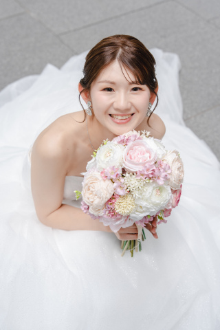見上げるような目線と、ふんわりとした笑顔。ブーケを抱える仕草が加わることで、やわらかな雰囲気が生まれました。作り込まない自然な表情が、そのまま写真に表れている一枚です。