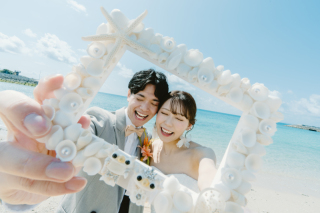 沖縄の青い海でお二人の思い出の詰まったアイテム。その中に映るお二人のとっても素敵な笑顔！お二人と一緒にシーサーたちもドレスとタキシードを着ていてとってもかわいいです♡