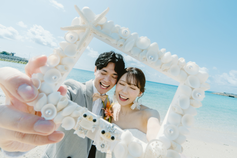 沖縄の青い海でお二人の思い出の詰まったアイテム。その中に映るお二人のとっても素敵な笑顔!お二人と一緒にシーサーたちもドレスとタキシードを着ていてとってもかわいいです♡